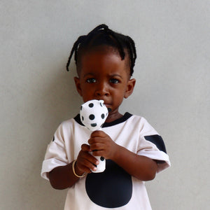 Cute baby holding the Dotty Rattler, a handmade soft velvet pon pon rattler.