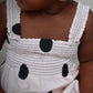 Bubble Oneis in sand color with polka dots, featuring a gathered leg opening and cuffed sleeves for comfort and style, crafted from 100% organic cotton.