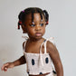 Young child wearing a polka dot dress against a plain background